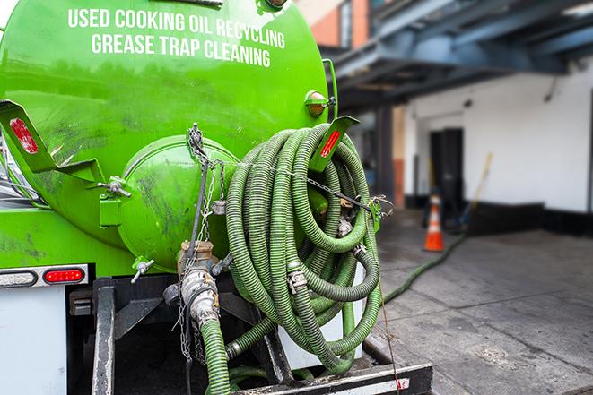 a grease trap being pumped by a sanitation technician in Mount Morris IL